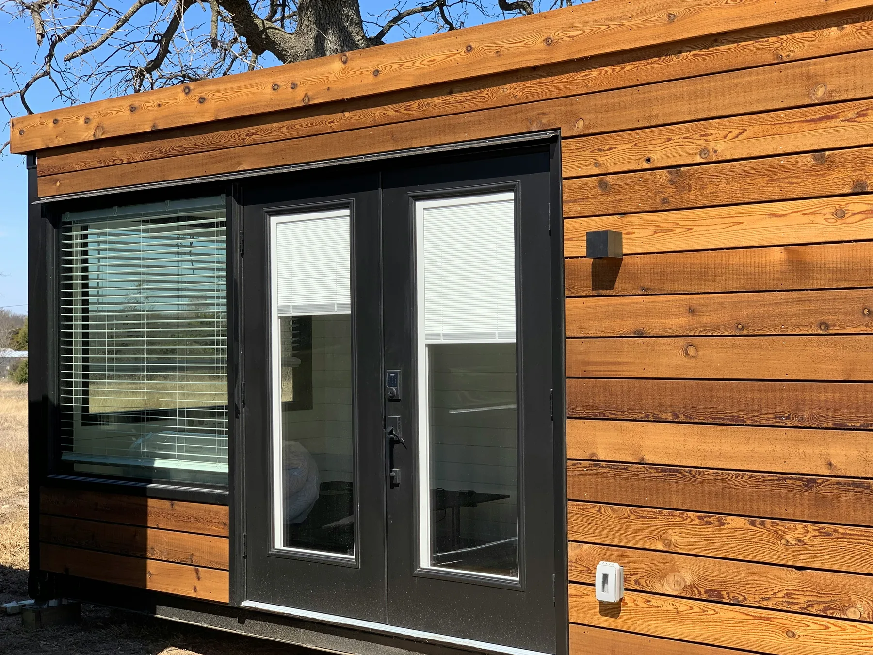 Detalle exterior de una casa container con revestimiento de madera
